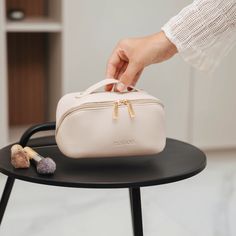 a person is holding a white bag on a black table next to a small stuffed animal