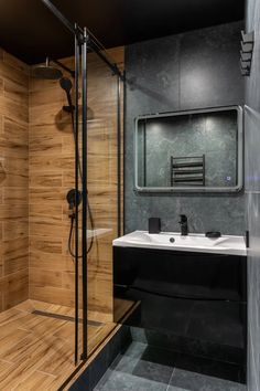 a bathroom with wooden walls and tile flooring on the shower wall, along with a black sink