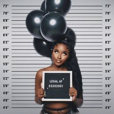 a mug shot of a woman holding a sign with balloons on top of her head