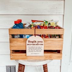 a wooden crate filled with food sitting on top of a white table next to a wall