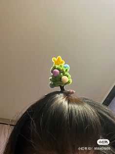 there is a small toy tree on top of the head of a child's head