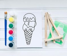 an ice cream cone with two scoops of ice cream on it next to paintbrushes and markers