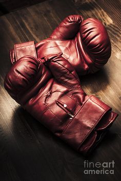 pair of red leather gloves sitting on top of a wooden table