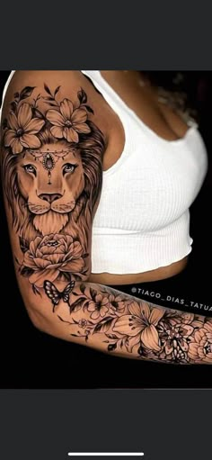 a woman's arm with flowers and a lion tattoo on the side of her body