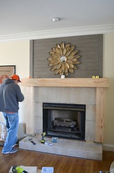 a man standing in front of a fire place next to a wall mounted sunflower