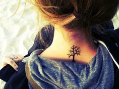 a woman with a small tree tattoo on her neck and back side ribcage