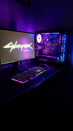 two computer monitors sitting next to each other on top of a black desk in a dark room