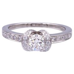 A 1999 Tiffany & Co Ribbon Diamond ring featuring a .42 ct Center H VS1 diamond.  The diamond is set in Tiffany's Ribbon style ring, which is adorned with an additional 29 diamonds , E-G Color , VS clarity, weighing a total of .30cts.  Included with the ring is the original Tiffany and Co. Certificate and Tiffany evaluation report.  This ring was recently polished, and restored to brand new condition.  Fully hallmarked with logo, serial numbers and metal content.  Currently a size 6.25 and can be re-sized.   Condition Report Excellent.   Recently polished, and in brand new condition.  See Video for details.  The metal shows an excellent shine, with no scratches or dents. The hallmark stamps are in perfect shape.  The paperwork includes original certificate , retail replacement documents fr Tiffany Engagement Ring, Ribbon Style, Vs1 Diamond, Tiffany And Co, White Satin, Jewelry Rings Engagement, Tiffany & Co., Ring Verlobung, Diamond Shapes