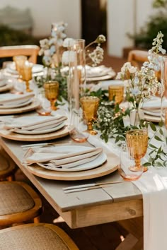 the table is set with white and gold place settings