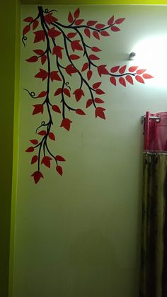 a bathroom with a tree painted on the wall next to a toilet and shower curtain