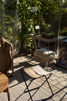 a chair and table on a patio with trees in the backgroung area