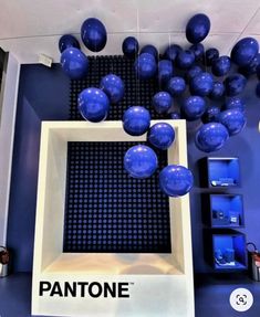 blue balloons are floating in the air above a pantone sign