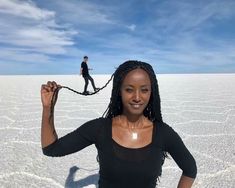 a woman standing in the middle of an empty desert