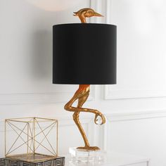 a lamp that is sitting on top of a table next to a basket and box