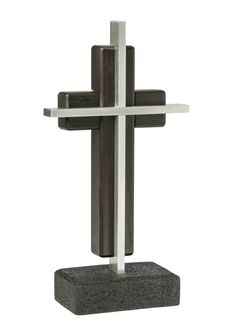 a cross is shown on top of a black stone block with silver bars around it