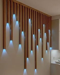 a bathroom with wooden slats and blue lights on the wall next to the sink