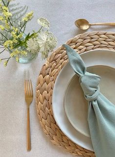 a place setting with napkins, silverware and flowers