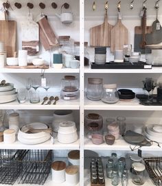 the shelves are filled with different types of dishes and cooking utensils on them