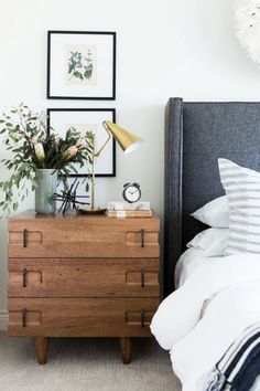 a bedroom with a bed, nightstand and pictures on the wall