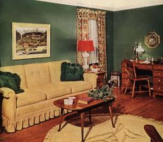 a living room with green walls and wooden floors is pictured in this image, there are two couches on either side of the coffee table