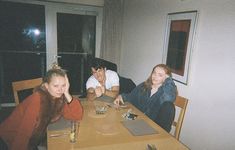 three people sitting at a table with drinks