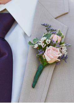 a man wearing a suit and tie with a boutonniere on his lapel