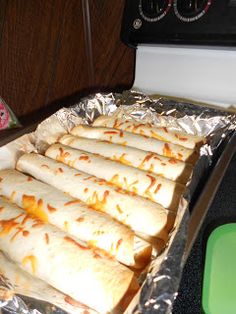 there are many burritos on the pan ready to be cooked in the oven