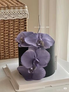 purple flowers are sitting on top of a black container