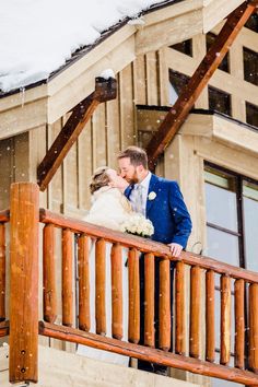 a bride and groom kissing on the balcony of their ski lodge wedding venue in colorado