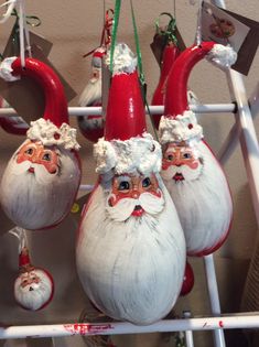 some ornaments are hanging from a rack with santa claus faces on them and other decorations