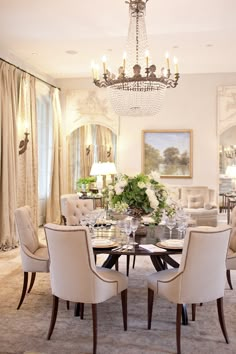 a formal dining room with chandelier and chairs