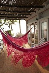 a red hammock sitting on top of a wooden floor