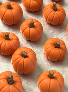 small orange pumpkins sitting on top of a white tablecloth covered in frosting