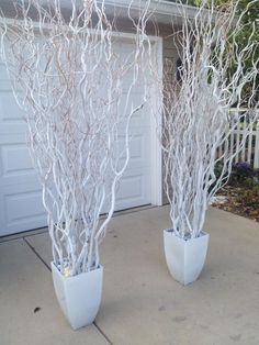 two white planters sitting on top of a cement floor next to a garage door