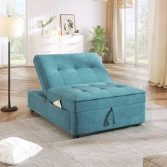 a blue futon bed sitting on top of a wooden floor next to a lamp