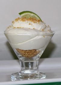 a dessert in a small glass bowl with a lime slice on the rim and crumbs