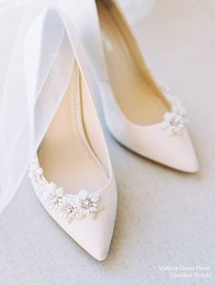 the bride's wedding shoes are adorned with flowers and pearls, along with a veil