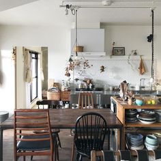 a kitchen filled with lots of wooden furniture and decor on top of a hard wood floor