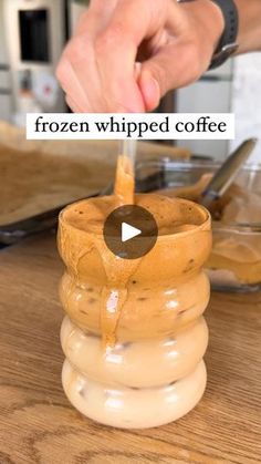 a person pouring coffee into a cup on top of a wooden table with the words frozen whipped coffee