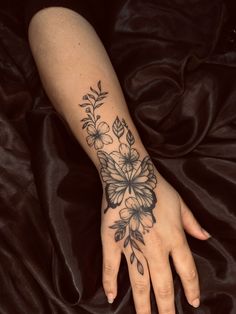 a woman's hand with a flower tattoo on it