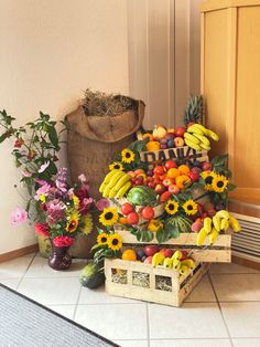 a bunch of fruits and vegetables are on the floor next to a basket with sunflowers