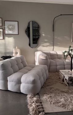 a living room filled with lots of furniture and pictures on the wall above it's couches