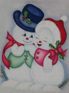 two snowmen are hugging each other with christmas decorations on their hats and scarfs