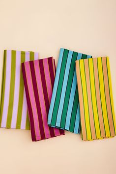 four different colored striped napkins sitting next to each other