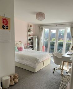 a bedroom with a bed, desk and chair next to a sliding glass door that leads to a patio