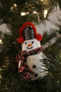 a snowman ornament hanging from a christmas tree