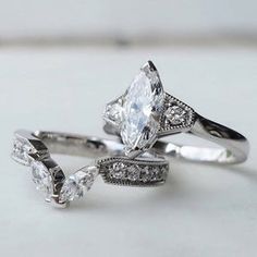 three wedding rings with diamond accents on each one and an engagement ring in the middle