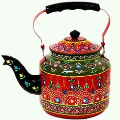 a red and green tea kettle with designs on it