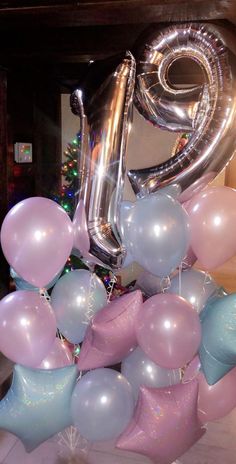 a large number twenty balloon arrangement in front of a fireplace with balloons and confetti