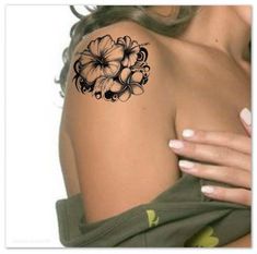 a woman's shoulder with flowers on it and the arm tattoo design in black ink